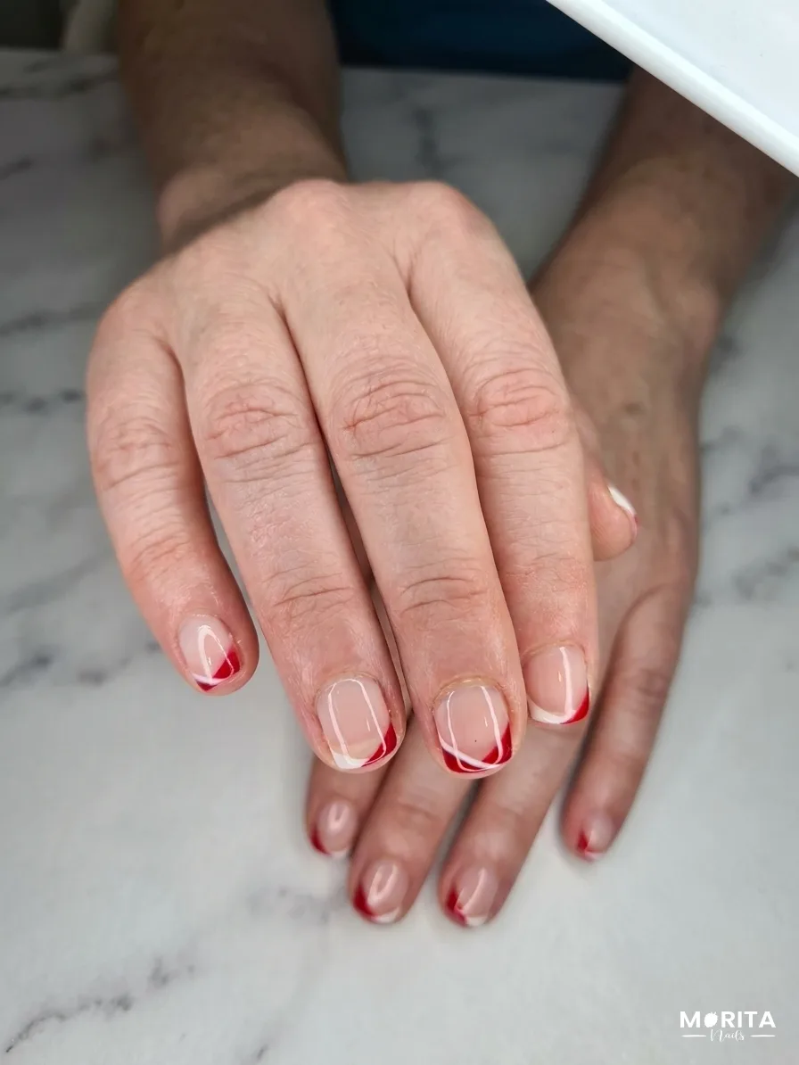 Uñas con un perfecto francés rojo y blanco entre una base natural e impecable que lo hace lucir lleno de vida.