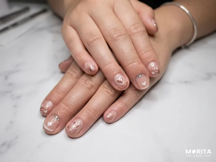 Uñas con francés, brillo y corazones un clásico...