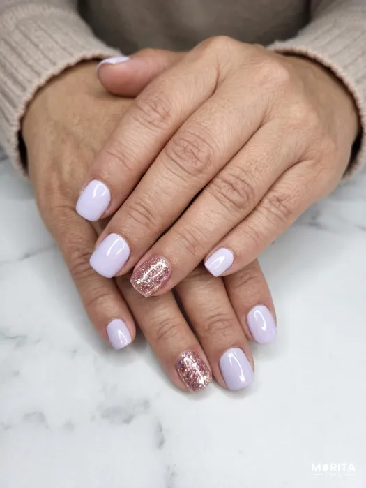 Uñas lisas en lila con una uña brillante para da...